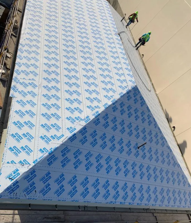 Professional roofers installing underlayment on a metal roof in Bellefonte